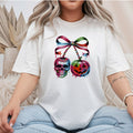 White Gildan Softstyle tee mockup with a drippy skull and jack-o-lantern hanging like cherries from a rainbow ribbon bow